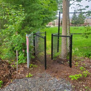 A black fence with a sharp bend in it that narrows to 25 inches